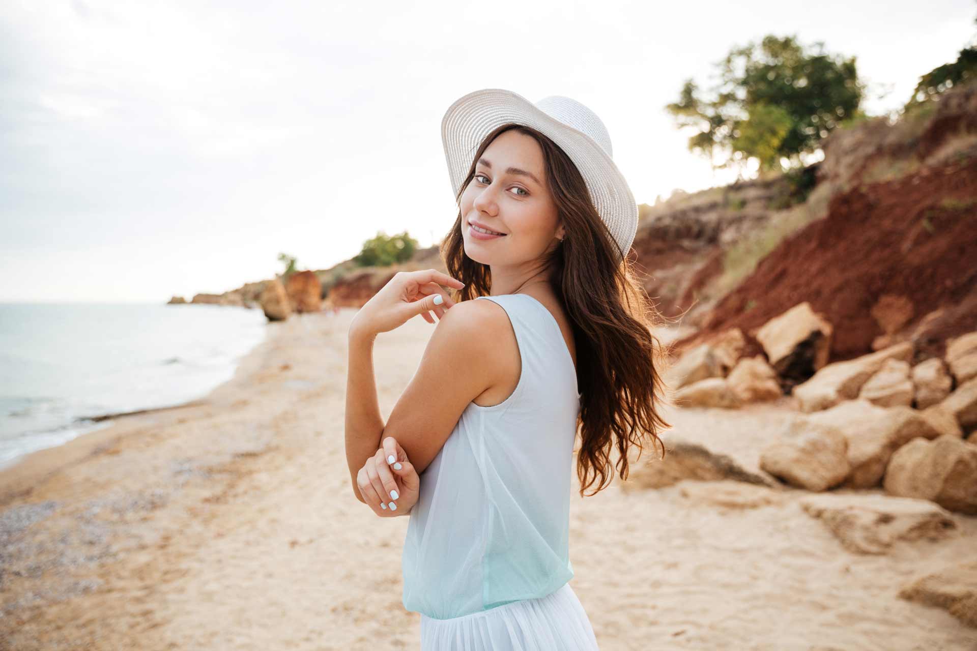 happy-young-woman-in-white-hat-waalking-near-the-PMPGEFG.jpg